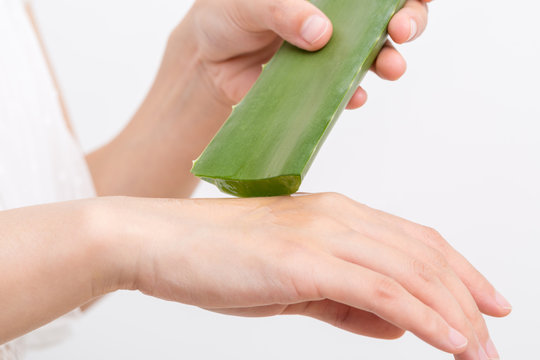 Fototapete - Female hand applying aloe vera gel on a skin. Natural alternative medicine.