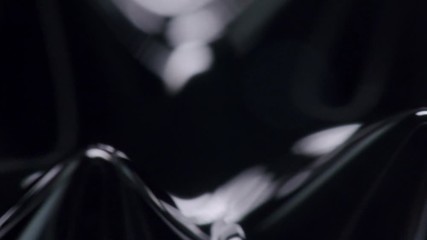 small glossy black spikes hovering around. in the background more symmetrical structures moving. black polished three dimensional structures moving freely.