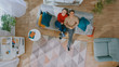 © Gorodenkoff - Young Beautiful Couple is Lying Down on Sofa. Cozy Living Room with Modern Interior with Plants, Table and Wooden Floor. Top View.