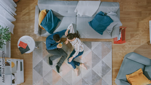 Fotografía Happy Couple is Sitting on a Floor and Talking
