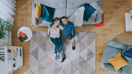  Couple is Sitting on a Floor and Talking. Man Gives Girl a Hug. They Dream about Future and Look Above. Cozy Living Room with Modern Interior. Top View.
