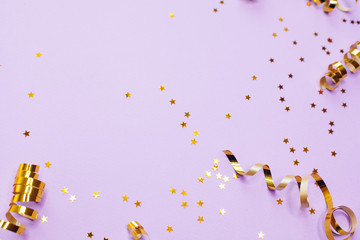 Golden decorations and sparkles on pale purple background