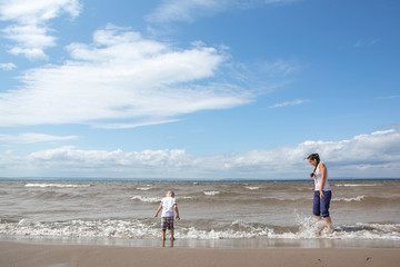 The child walks with his mother on the beach