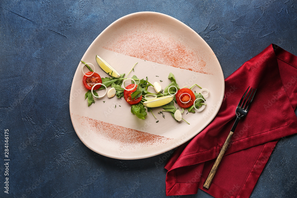 Plate with tasty arugula salad on color background