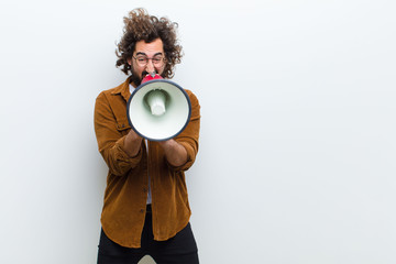 young man with crazy hair in motion shouting and holding a megap