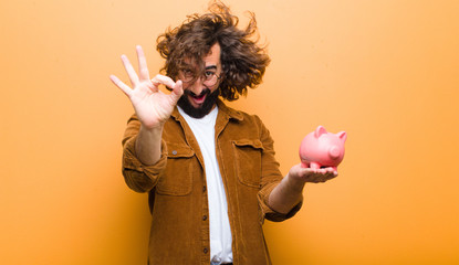 Wall Mural - young man with crazy hair in motion and a piggy bank