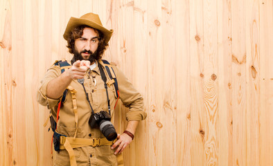 young crazy explorer with straw hat and backpack on wood backgro