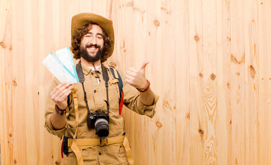 young crazy explorer with straw hat and backpack on wood backgro