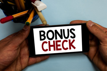 Conceptual hand writing showing Bonus Check. Business photo showcasing something in addition to what is expected or strictly due Man holding cell phone looking messages apps cup markers