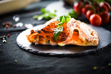 Wall Mural - tasty italian calzone pizza with fresh ingredients and vegetables