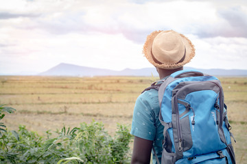 Wall Mural - African tourist  traveler man with backpack on view of mountain background