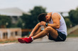 © qunica.com - Young runner in sleeveless with bottle of water resting from training