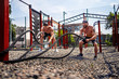 © zamuruev - Athletic man working out with rope at street gym yard. Strength and motivation. Outdoor workout. fitness, sport, exercising, training and lifestyle concept .
