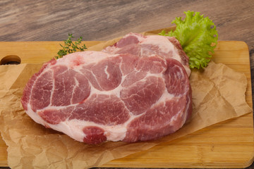 Raw pork steak over wooden board