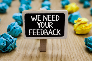 Poster - Text sign showing We Need Your Feedback. Conceptual photo Give us your review thoughts comments what to improve Paperclip hold written chalkboard behind paper lumps on woody deck