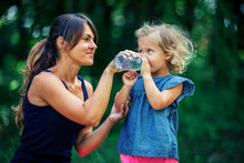 Mother Gives A Little Girl To Drink Water