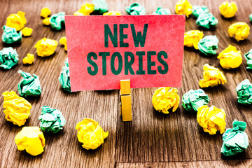 Poster - Word writing text New Stories. Business concept for imaginary or real people and events told for entertainment Clothespin holding pink note paper crumpled papers several tries mistakes