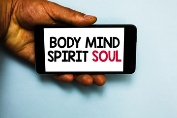 Handwriting text Body Mind Spirit Soul. Concept meaning Personal Balance Therapy Conciousness state of mind Human hand hold mobile phone with some black and red color letters