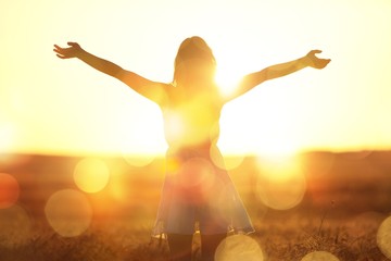 young woman on field under sunset light