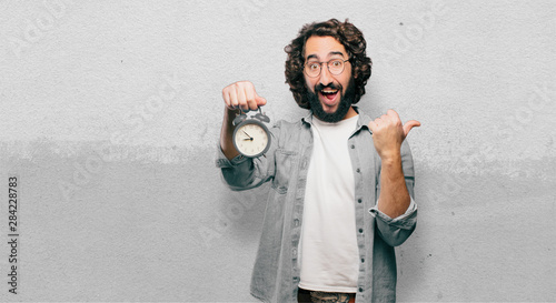 Zdjęcie: young fool man with an alarm clock young fool man with an alarm clock