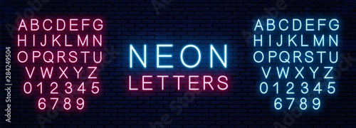 Cuadros en Lienzo Bright neon letters of red and blue color isolated on brick wall background