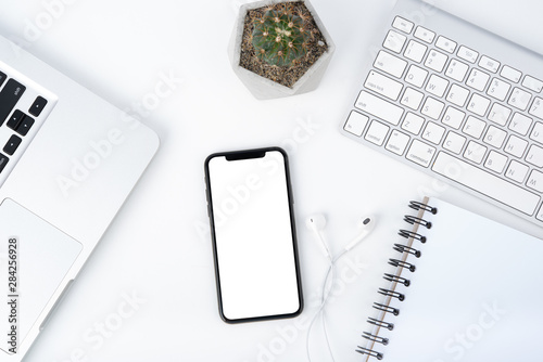 Cuadros en Lienzo Modern white office work table with smartphone mock up laptop ,earphone and catu