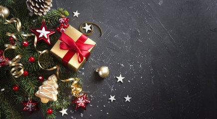 Wall Mural - christmas dark black background with beautiful texture and golden gift box with red ribbon, fir bran