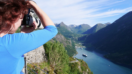 Wall Mural - Tourist taking photo of fjord landscape, Norway