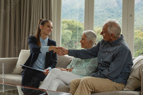 Fotografía Active senior man shaking hands with real estate agent in living room