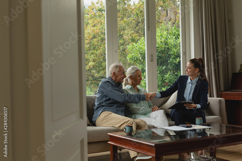 Fotografía Active senior man shaking hands with real estate agent in living room