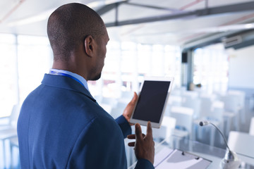 Wall Mural - Male speaker practicing his speech on digital tablet in business seminar