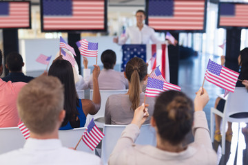 Wall Mural - Business people waving an American flag in business seminar