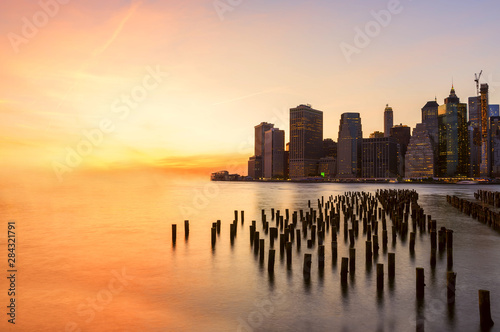 View from the water of the bay on the night city center of New York at sunset Fotobehang