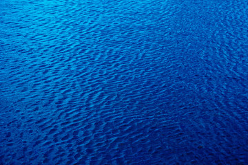 Shining dark blue wavy water surface ripple background