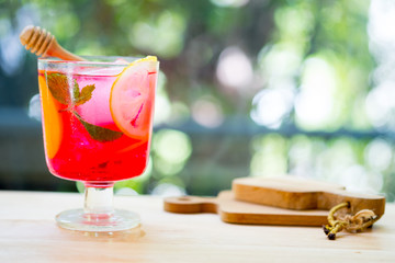 Pink and red fresh colorful exotic alcoholic cocktail with peach, orange and ice in the bar.