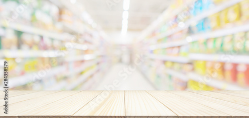 Fotografía Empty wood table top with abstract supermarket grocery store aisle blurred defoc