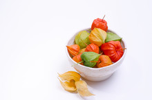 Multicolor Physalis Flowers In A Plate Against White Background. Template With Ripe Red Physalis Flowers.