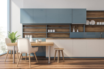 Blue and wooden kitchen with counters and table