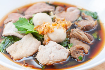 Thai popular street food braised pork noodles with black soya stew soup sauce. pork pig liverand garlic oil