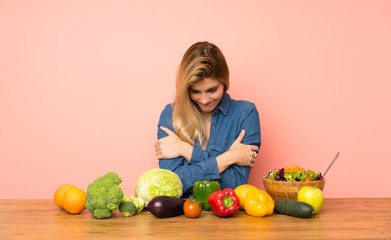 Wall Mural - Young blonde woman with many vegetables freezing