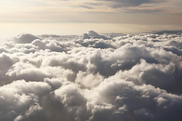 Sky view on the plane. Beautiful sky above clouds with dramatic light in the evening. Cabin view. Golden hours