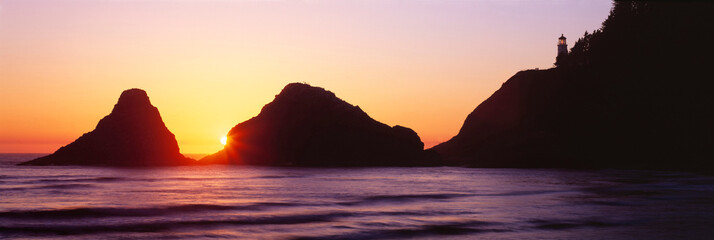 Poster - USA, Oregon, Heceta Head. The sun sets between two seastacks above Heceta Head Lighthouse on the Oregon coast.