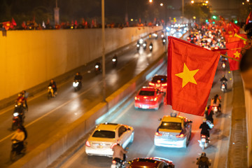 Vietnamese flags with crowd of Vietname football fans down the street to celebrate the win after soccer