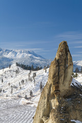 Canvas Print - USA, Washington, Peshastin Pinnacles State Park. Jutting rock towers above wintry orchard and mountains. 