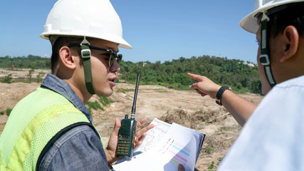 portrait of two engineer's or architect's dress with hardhat, safety helmet and safety vest have a meeting outdoors