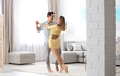 © New Africa - Beautiful young couple dancing in living at home