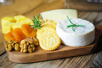 Wall Mural - cheese plate,camembert cheese ,rosemary ,crackers,dry apricot and walnuts