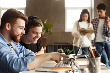 Wall Mural - University students at library studying together and connecting online