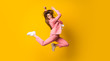 © luismolinero - Young woman jumping over isolated yellow wall