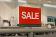 © Gazed - Red sale sign discount on clothing rack in modern shopping mall or department store with copy space. Business marketing advertising concept